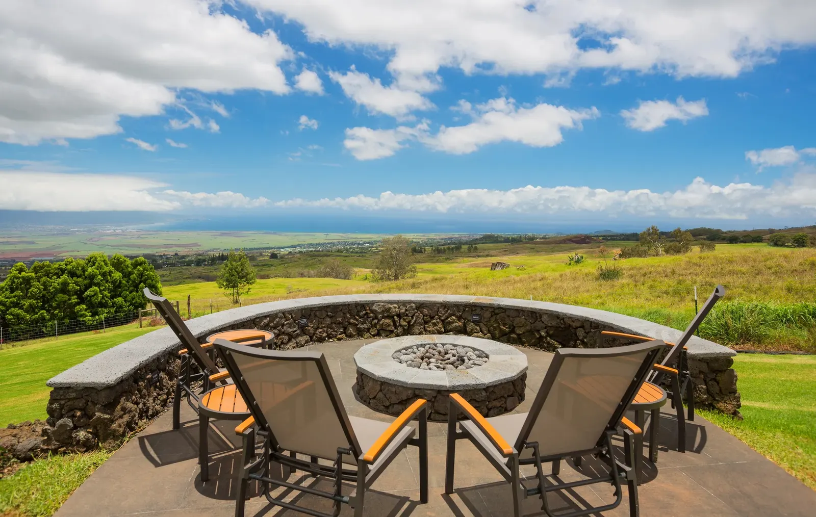 A stone fire pit with outdoor chairs