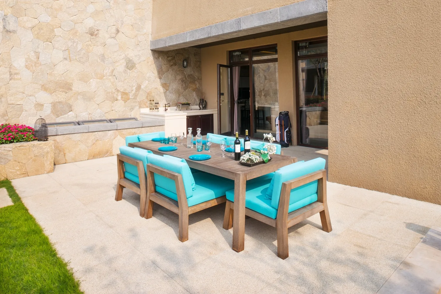 An outdoor kitchen bench and dining setting beside a pool