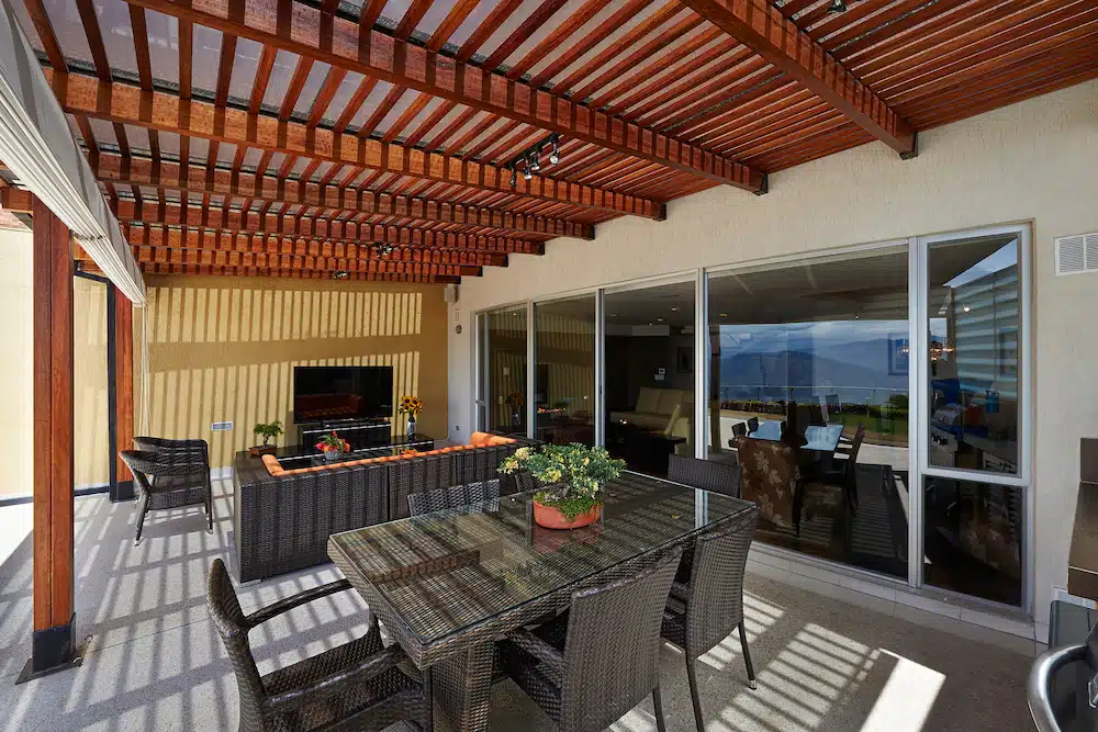 A timber pergola over an outdoor lounge and dining area