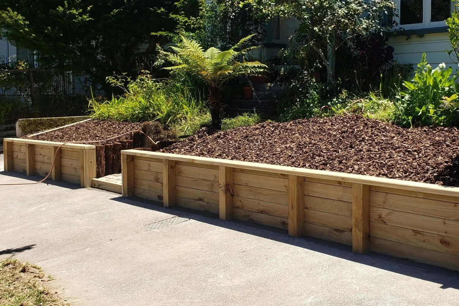 A timber sleeper retaining wall built along a driveway